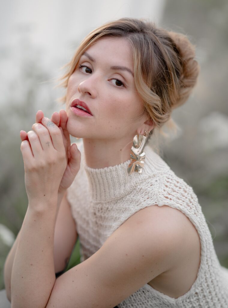 Modèle qui pose avec un maquillage naturel et un chignon banane