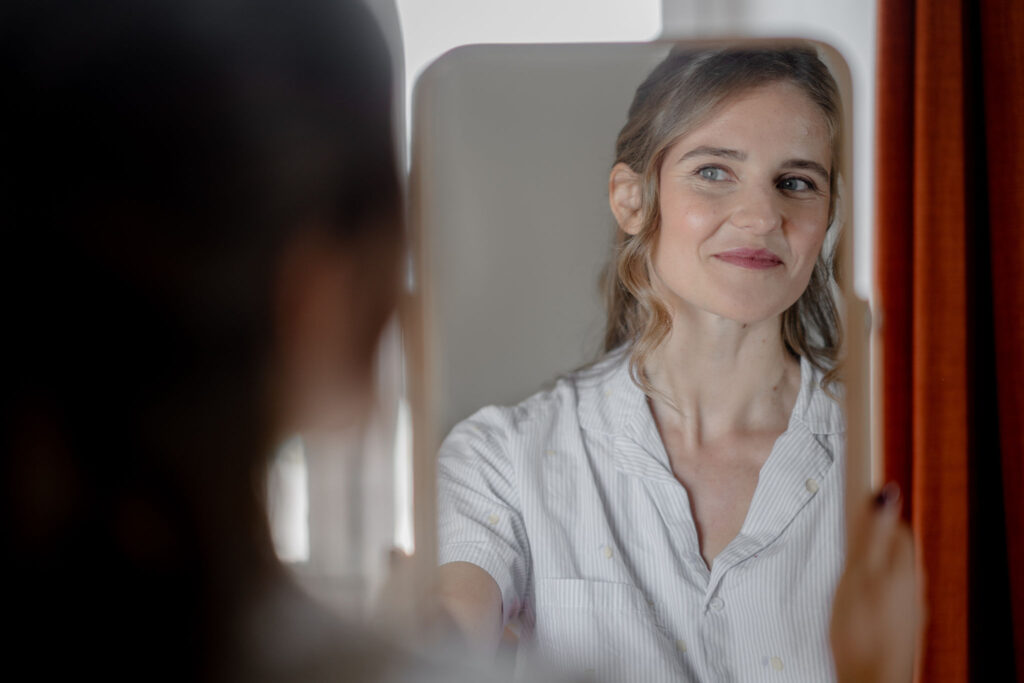 Mariée qui se regarde dans le miroir après s'être fait maquiller - cours de maquillage Lyon